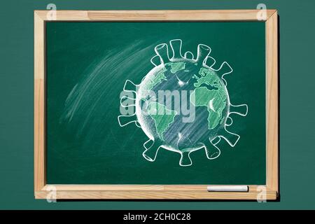 Planet Earth in shape of coronavirus  are drawn with chalk on a blackboard. Covid-19 concept. Back to School concept. Travel concept. Stock Photo