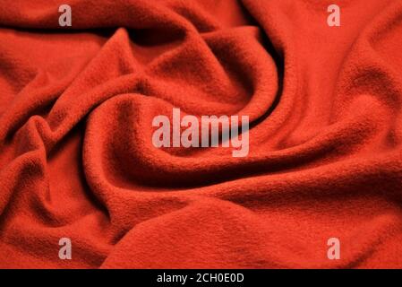 Red woolen fabric with waves. Crumpled fabric. Woolen shawl Stock Photo