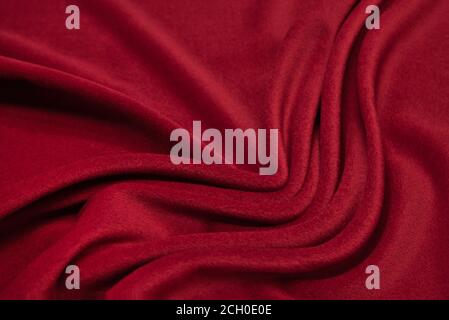 Red woolen fabric with waves. Crumpled fabric. Woolen shawl Stock Photo