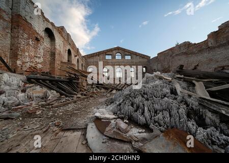 old ruined brick building, walls. Without a roof, under an open blue sky. piles of garbage inside Stock Photo