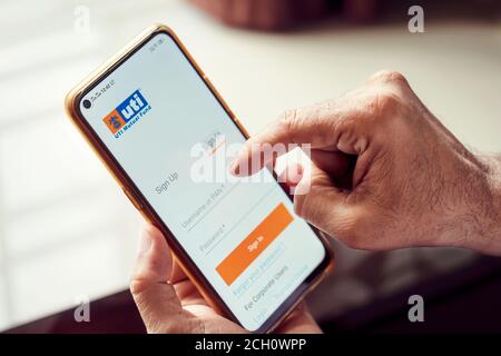 Kolkata, West Bengal, India, September 13, 2020 : UTI Asset Management Company IPO Background. Man holding a smartphone and logging in at UTI Mutual F