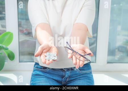 woman holds out glasses and contact lenses. myopia and eyesight problem concept. Stock Photo