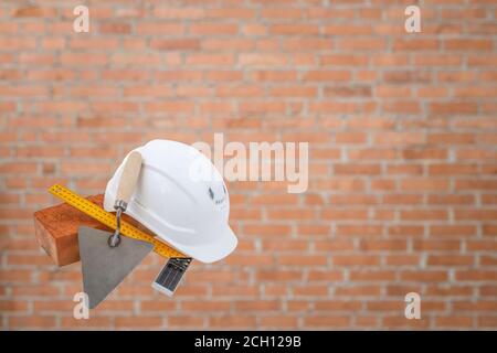 Mason tools. Brick, white helmet, trowel and construction square, isolated on the white background. concept of the construction Stock Photo