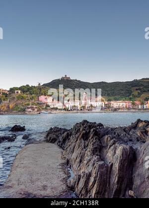 View of castle on hill above town buildings from across the harbour, Collioure, France Stock Photo
