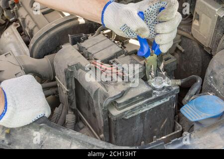 man hands using pliers remove car battery terminals to change the new one. replacing the car battery. repair car concept Stock Photo