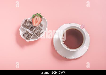 Tea in a white cup, saucer and bowl of sweets on a pink background. low calorie sweets dessert concept Stock Photo