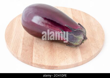 Fresh healthy eggplants on wooden background. Fresh eggplant lies on a wooden cutting board. Summer eggplant harvest ready for cooking on a wooden boa Stock Photo