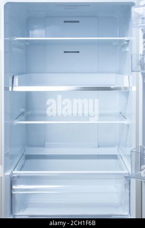 Empty open fridge with shelves, refrigerator. mockup background empty shelves for your products. open fridge shelf. Interior of an empty open white re Stock Photo