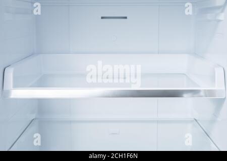 Background empty shelves in the refrigerator. Inside of clean and empty refrigerator with shelves. Shelves in empty open white fridge Stock Photo