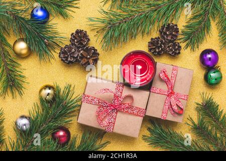 Christmas background with fir tree and decorations. Gift box, red candle, pine cones, branches on gold paper, holiday wallpaper. Festive  New Year car Stock Photo