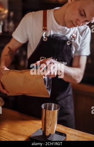 a handsome guy is pouring something in the cup at the cafe. closeup cropped photo Stock Photo