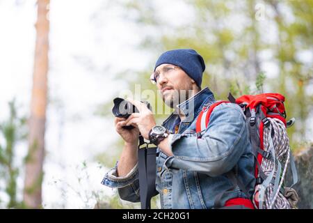 Middle aged bearded male hiker with photocamera. Man going to taking a photo. Stock Photo