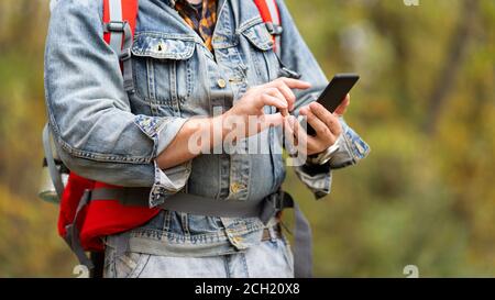 Close up male hiker hands using mobile phone. Man taking help of mobile phone for navigation in forest. Stock Photo