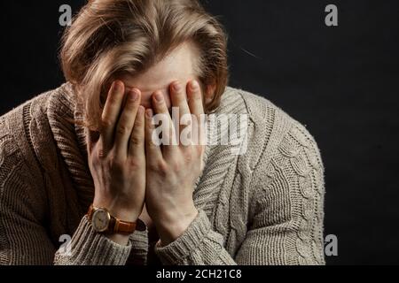 Close up portrait of shy stong young man. Isolated on black background Stock Photo