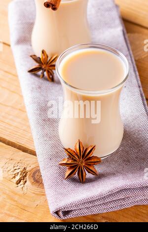 Herb tea with milk and spices. Homemade Indian Masala Chai Tea on wooden boards. Autumn drink in turkish tea cups Stock Photo