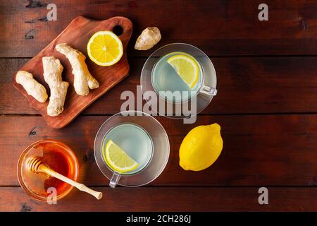 Ginger tea with lemon. Two cups of ginger tea with lemon and honey on wooden background. Top view Stock Photo