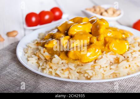 Rice with chicken curry sauce with cashew on white wooden background. selective focus, close up. Stock Photo