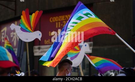 LGBT equality march. Young people wearing rainbow clothes and symbols are fighting for LGBTQ+ rights. Rainbow flags, banners. Stock Photo