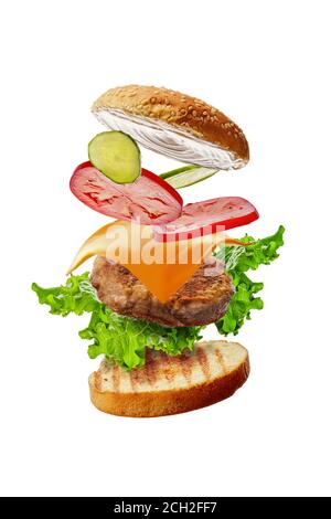 Burger with flying ingredients isolated on white background Stock Photo