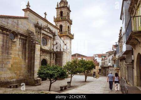 Cangas de Morrazo, Vigo, Spain : People walk past the church of Santiago built in 1493 in the old town of Cangas. Stock Photo