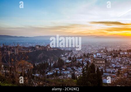 Granada, Spain - January 17th, 2020 : Alhambra palace and Unesco listed Albaicin district overview at sunset as seen from San Miguel Alto viewpoint.