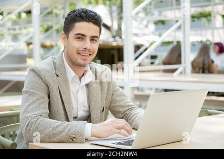 Happy young successful manager or agent in formalwear looking at you with smile Stock Photo