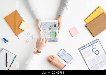 View of hands of two contemporary analysts or brokers discussing financial data Stock Photo