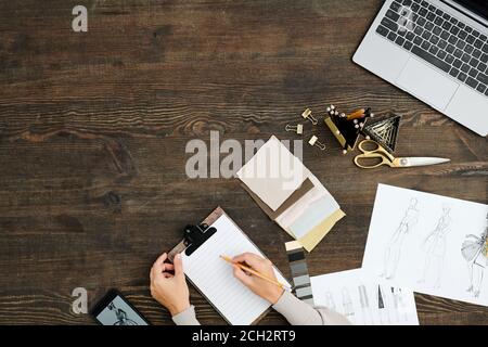 Flat layout of hands of young fashion designer with pencil over blank paper Stock Photo