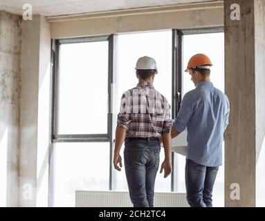 back view photo. two men are talking about the development of a city in the construction area Stock Photo