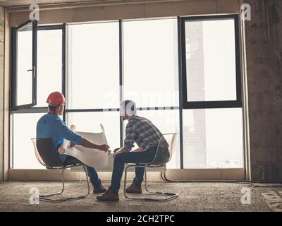 talented engineer is talking with a client in front of the panorama window. back view photo Stock Photo