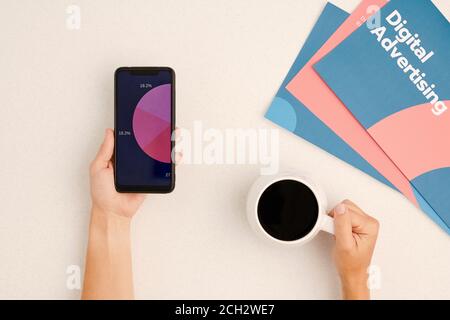 Flatlay of hands of contemporary businessperson having coffee and working Stock Photo
