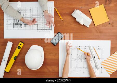 Above view of hands of creative architects during discussion of sketches Stock Photo