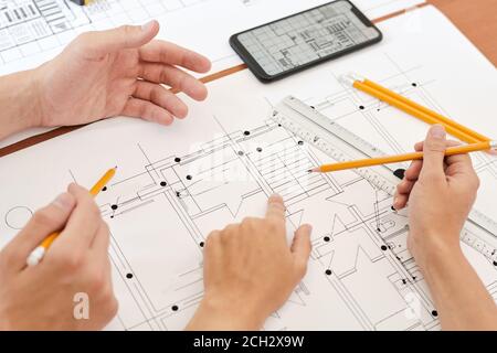 Hand of young engineer with pencil pointing at detail on sketch of new building Stock Photo