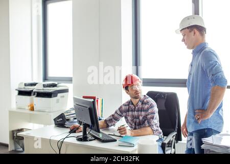 two talented successful engineers discussing work together in office with panorama window. close up photo. job concept Stock Photo