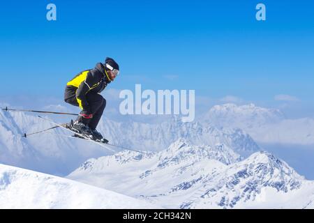 Jumping skier at jump with alpine high mountains copy space for text Stock Photo