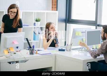 female and male programmers are having an arguement in the office with loft interior. woman is warning male employee Stock Photo