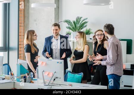 young office managers are cooperating together. CEO explaining the structure of his company to guest Stock Photo