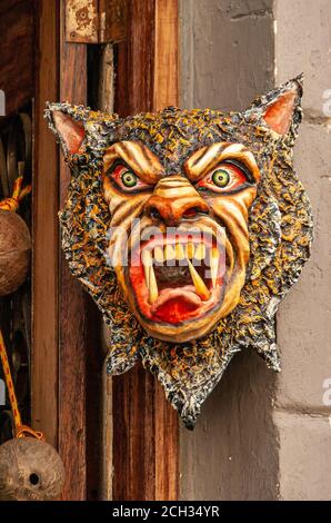 Panama City, Panama - November 30, 2008: Scary, colorful mask with animal and people characteristics, fixed on wall with door frame downtown. Stock Photo