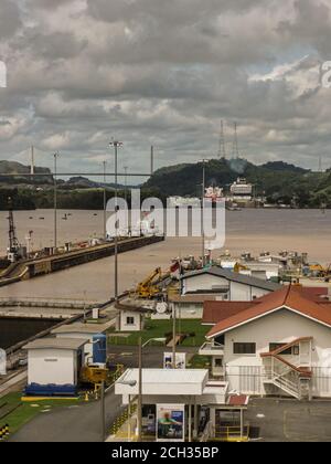 City of Knowledge, Panama - November 30, 2008: Miraflores locks. Brown water lake between different locks with ships. Cloudscape, green mountains and Stock Photo