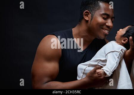 young happy, cheerful man is playing with his baby girl. father talking with his cute infant. entertainment concept. daddy enjoying spending time with Stock Photo