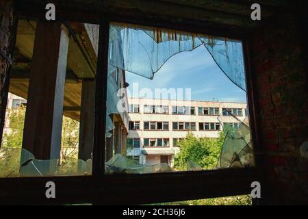 Abandoned industrial building with broken window glass, close up. Stock Photo