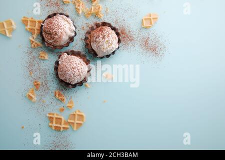 Top view of vanilla ice cream balls in waffle and chocolate bowl on blue background Stock Photo