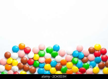 Colored balls of sugar on a white background. Chocolate candies covered with multicolored sugar glaze. Place for text Stock Photo