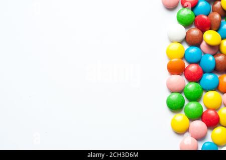 Colored balls of sugar on a white background. Chocolate candies covered with multicolored sugar glaze. Place for text Stock Photo