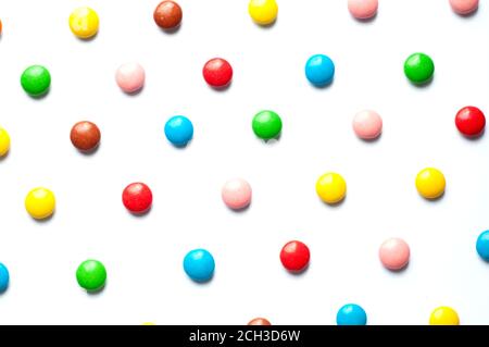 Colored balls of sugar on a white background. Chocolate candies covered with multicolored sugar glaze. Stock Photo