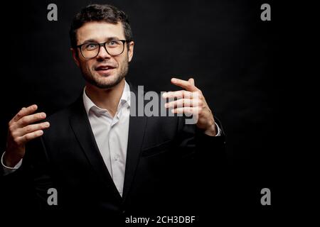 young pleasant man is sharing with his impressions after vacation. guy is talking colleagues about happy holidays Stock Photo