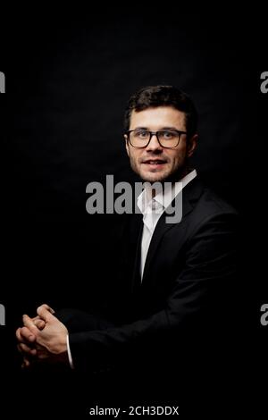 clever successful lawyer sitting with crossed legs. side view photo. smart student is waiting for the results of the exams Stock Photo