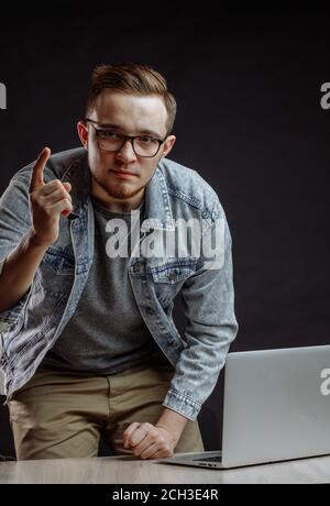 Portrait of a young red-haired handsome man pointing finger up. have a plan. Stock Photo