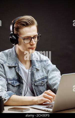 serious rewriter in denim jacket working with computer Stock Photo