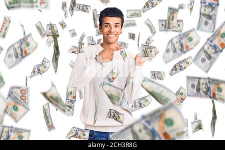 Young african amercian man wearing casual clothes amazed and smiling to the camera while presenting with hand and pointing with finger. Stock Photo